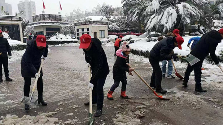 【一城冰雪一城暖】望城月亮岛街道的附近居民正在路边铲冰除雪,其中还有自发过来帮忙的小朋友。