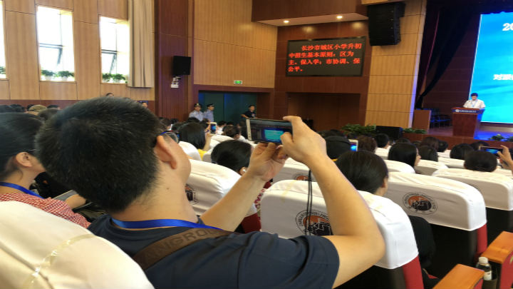 现场家长关注派位工作,用手机录下编制说明