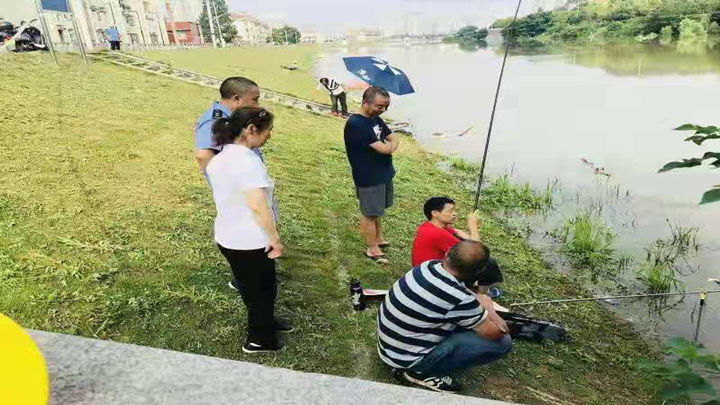 望月湖街道志愿者和工作人员劝阻在此钓鱼的市民离开。